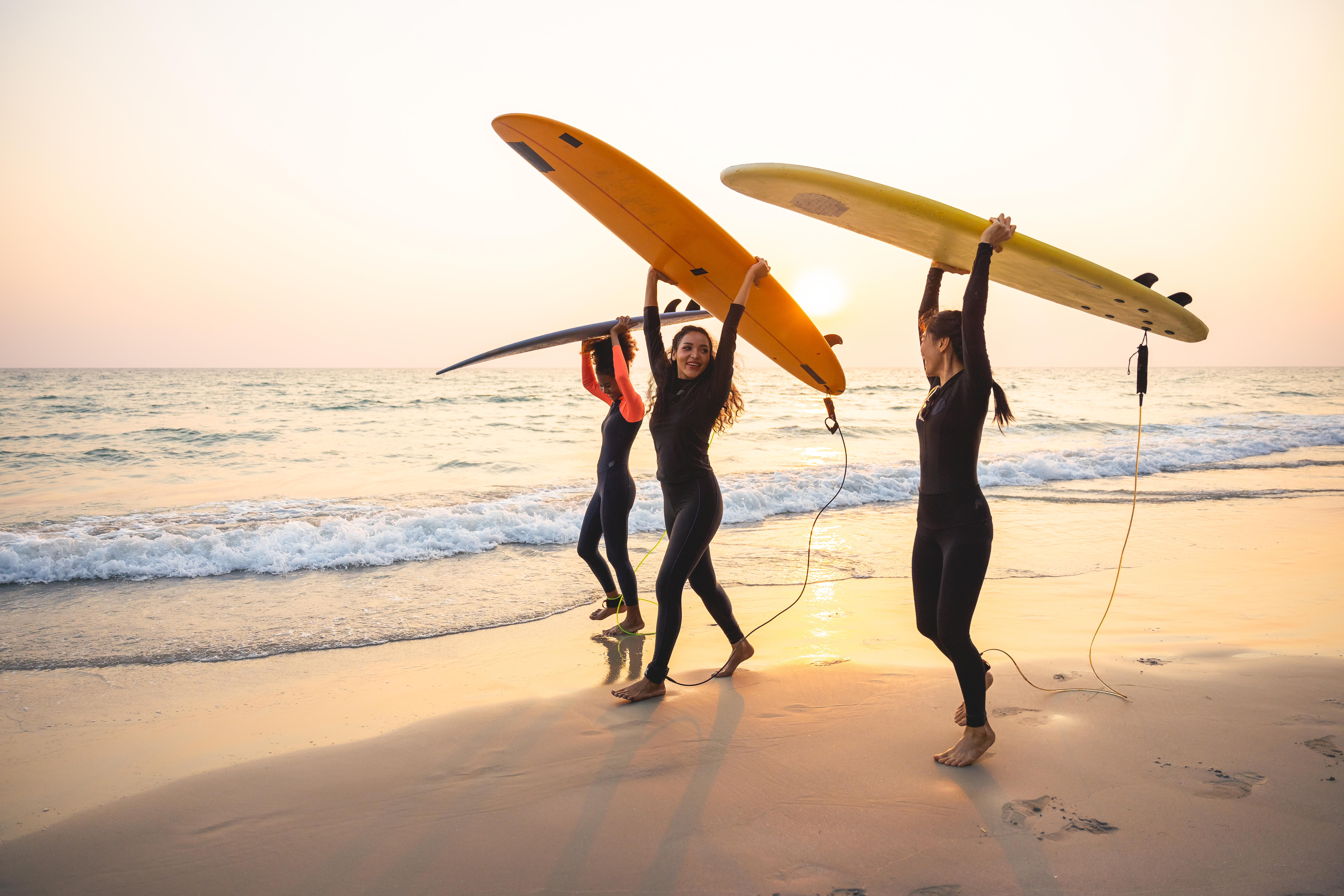 Group of female surfers walking on the beach